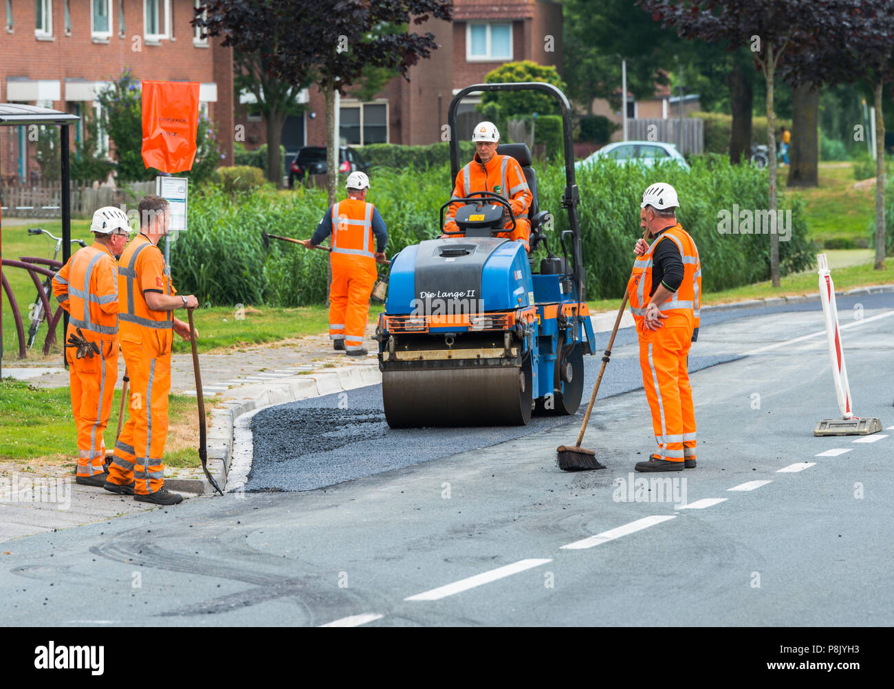 Hellevoetlsuis,Olanda-12-luglio-2018:costruzione i lavoratori sono occupati nel rinnovare la strada nel villaggio,uno in un bianco le strade hanno per ottenere nuovo asfalto e verrà chiuso per diverse settimane Foto Stock