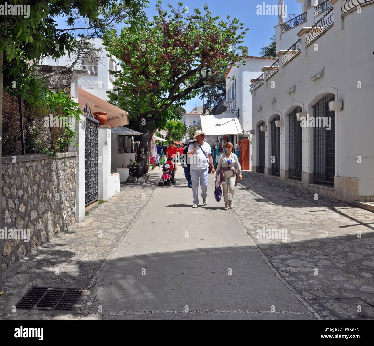 La gente cammina su una stretta strada dello shopping sull'isola Foto Stock