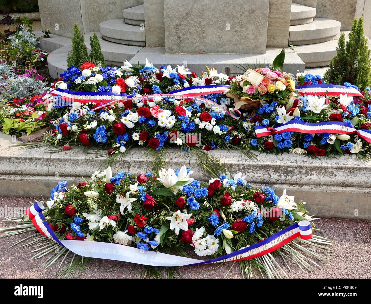 Blu, bianco e rosso dei fiori con nastri, posto nella parte anteriore di un francese war memorial in onore di coloro che morirono combattendo per la Francia, Avignon, Francia. Foto Stock