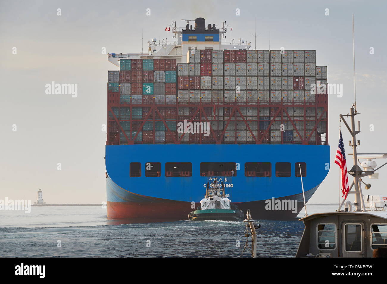 Vista posteriore della pila di contenitori di spedizione sul COSCO Container di spedizione Nave, CSCL autunno come lei lascia il porto di Los Angeles, California, USA. Foto Stock