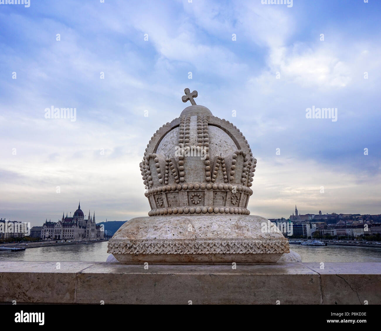 La corona ungherese statua sul ponte Margit con cielo blu e il Parlamento in background Foto Stock