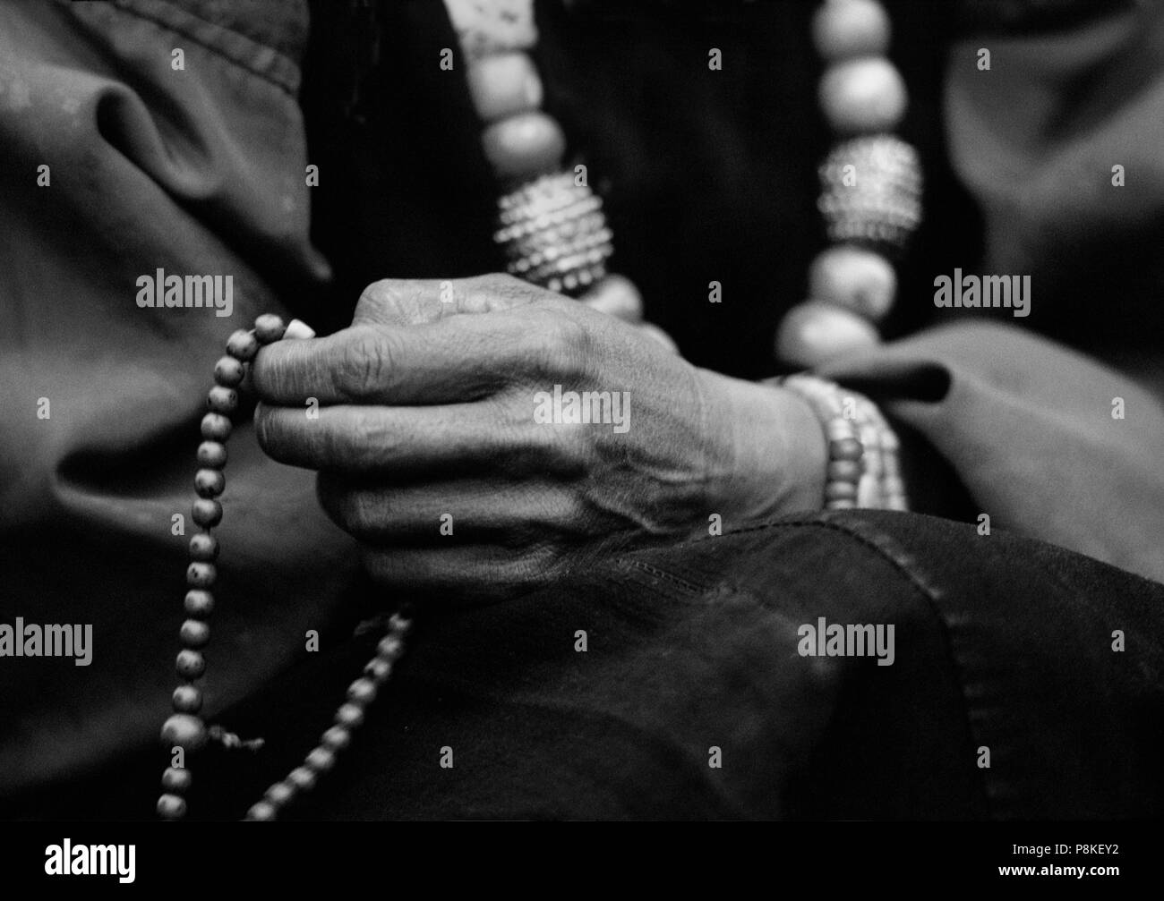 DOLPO donna perle conta sul suo rosario buddista e indossa un corallo e turchese collana in oro - Distretto di DOLPO, NEPAL Foto Stock