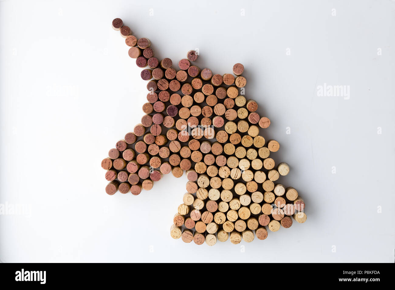 Unicorn mistico testa formata di utilizzati tappi in un design creativo su sfondo bianco Foto Stock