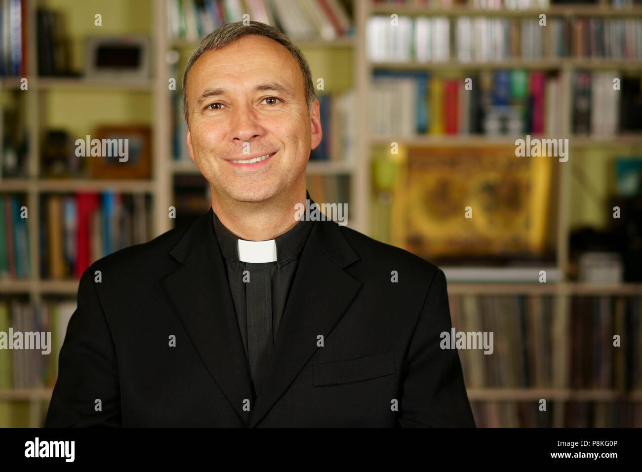 Guardare un buon sacerdote cattolico è studiare nella sua libreria. Egli sembra a noi di serenità, di pace e di ottimismo. Foto Stock