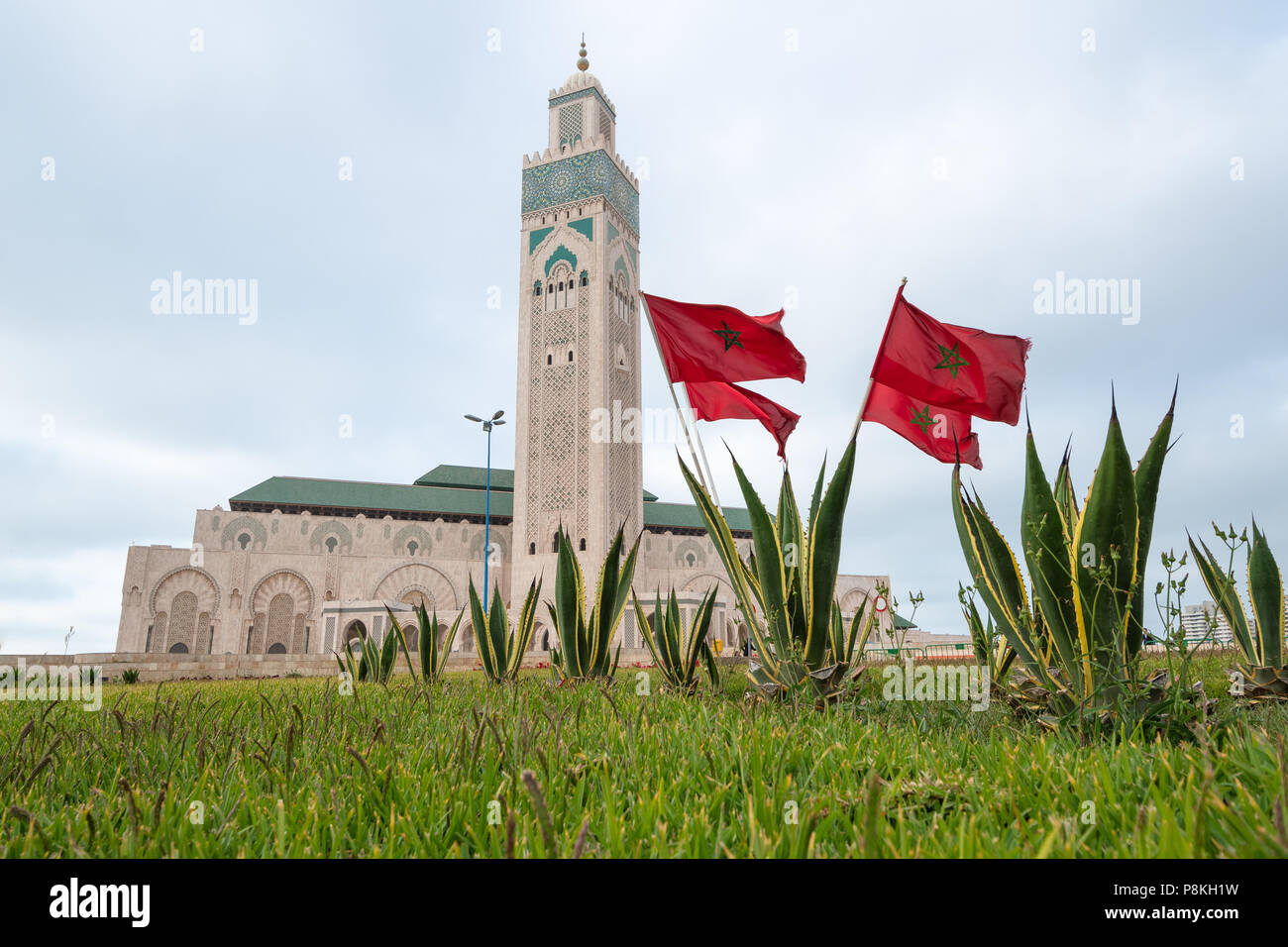 Moschea di Hassan II a Casablanca con bandiere marocchine e interesse foregrond Foto Stock