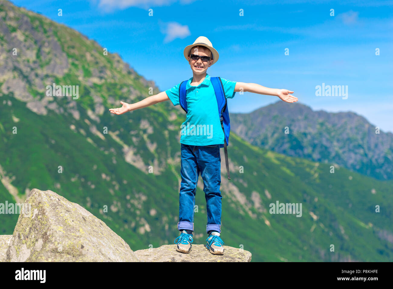 Traveler boy gode la bellezza delle montagne e la libertà in piedi sulla roccia Foto Stock