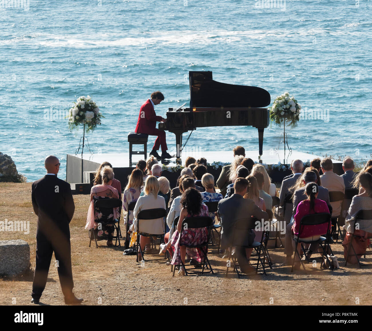 Newquay, Cornwall, Regno Unito. 12 luglio 2018. Rosamunde Pilcher attore Manuel Mairhoffer suona il pianoforte sulle scogliere,riprese 'My fratelli sposa' Fistral Beach,UK, 12th, Luglio 2018 Robert Taylor/Alamy Live News. Newquay, Cornwall, Regno Unito. Credito: Robert Taylor/Alamy Live News Foto Stock