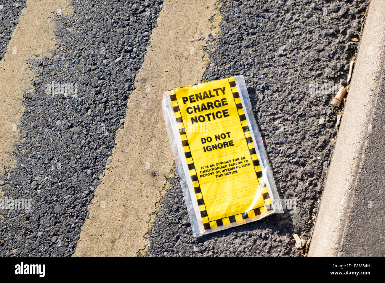 Scartata la penale preavviso. Parcheggio ammenda rimosso dal veicolo e gettato su una strada con doppio giallo linee, Nottinghamshire, England, Regno Unito Foto Stock