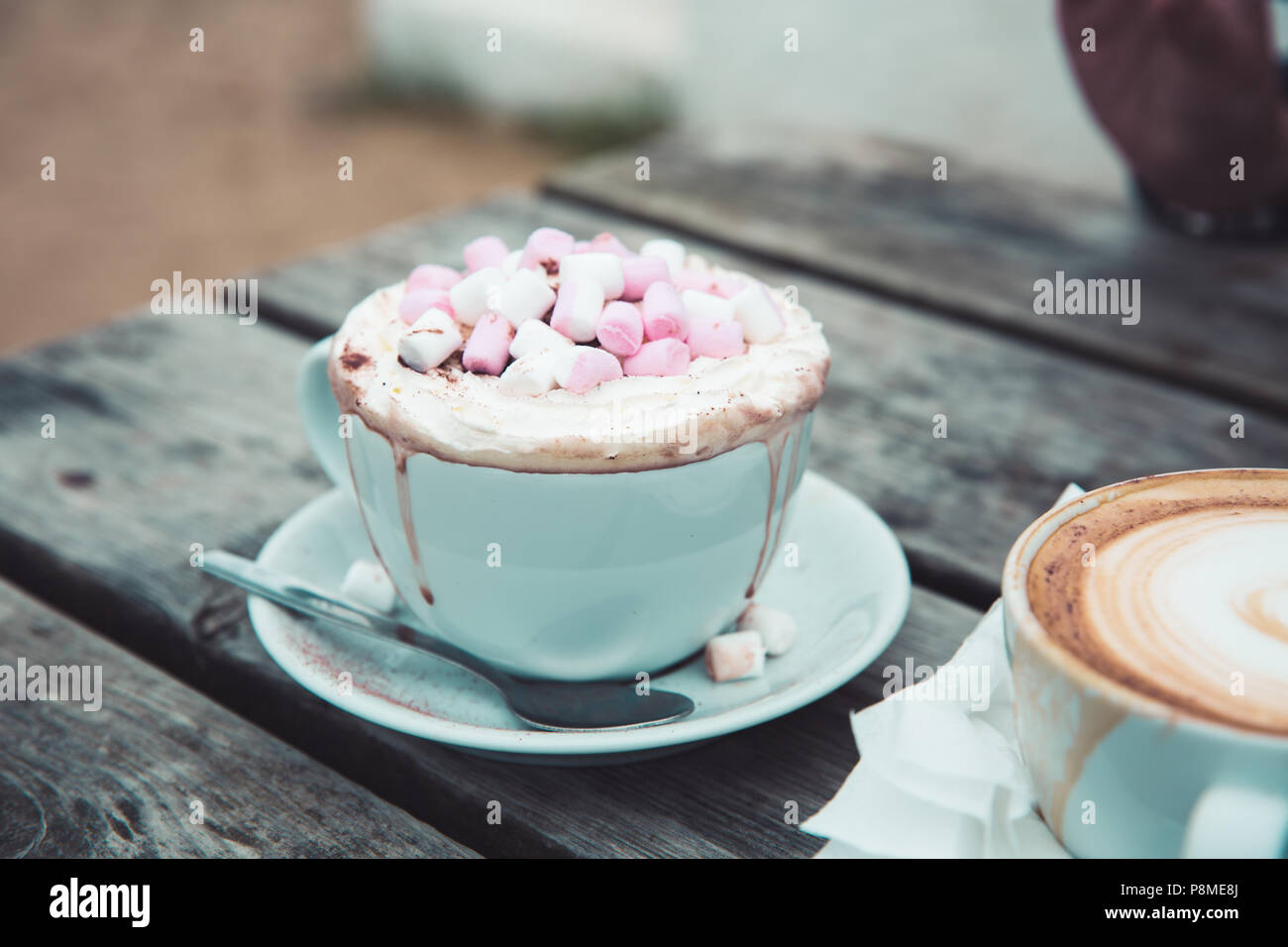 Un lusso cioccolata calda da bere in un elegante tazza e piattino con panna montata e marshmallows fusione e dribbling verso il basso la coppa Foto Stock Un lusso cioccolata calda da bere in un elegante tazza e piattino con panna montata e marshmallows fusione e dribbling verso il basso la coppa Foto Stock