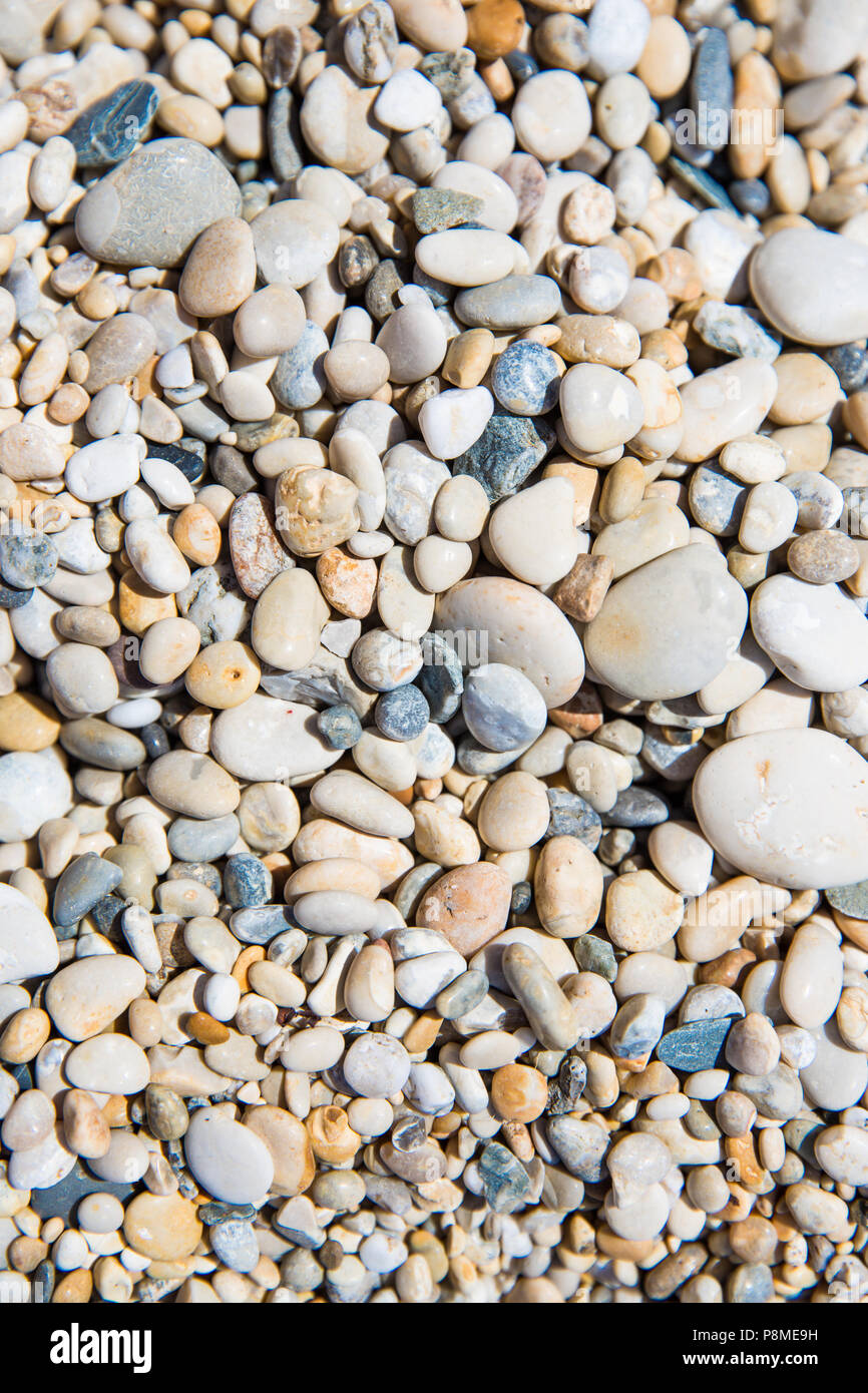 Un frame completo sullo sfondo di ciottoli e pietre su di una spiaggia di ciottoli in una trama di sfondo Foto Stock