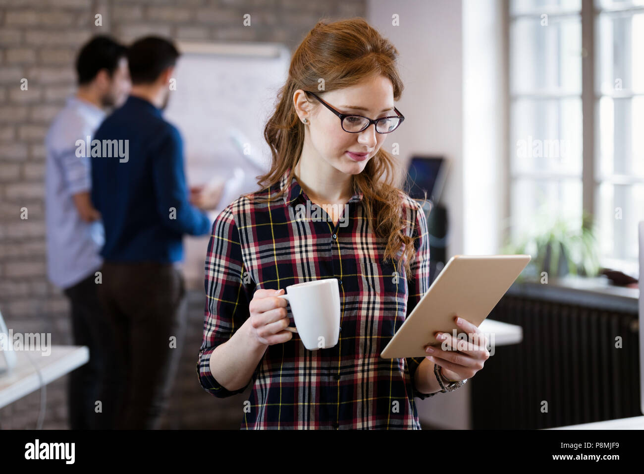 Giovane architetto attraente lavorando in ufficio moderno Foto Stock
