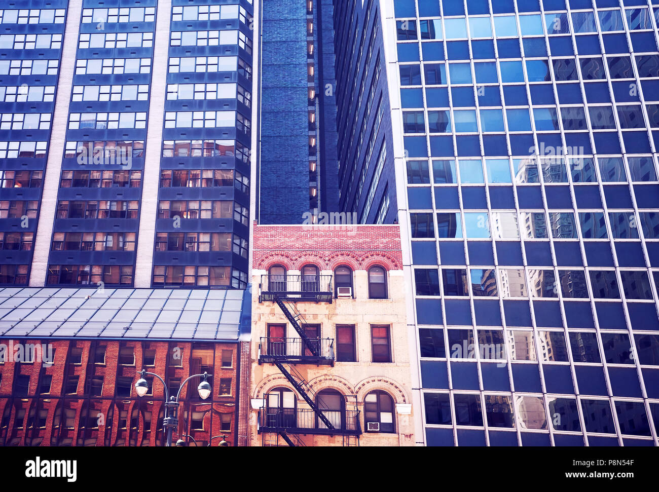 Vecchio edificio tra i moderni grattacieli di New York City, vintage viraggio applicata, Stati Uniti d'America. Foto Stock