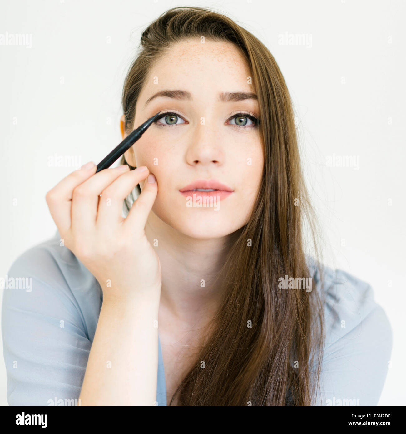 Donna di applicare eyeliner Foto Stock