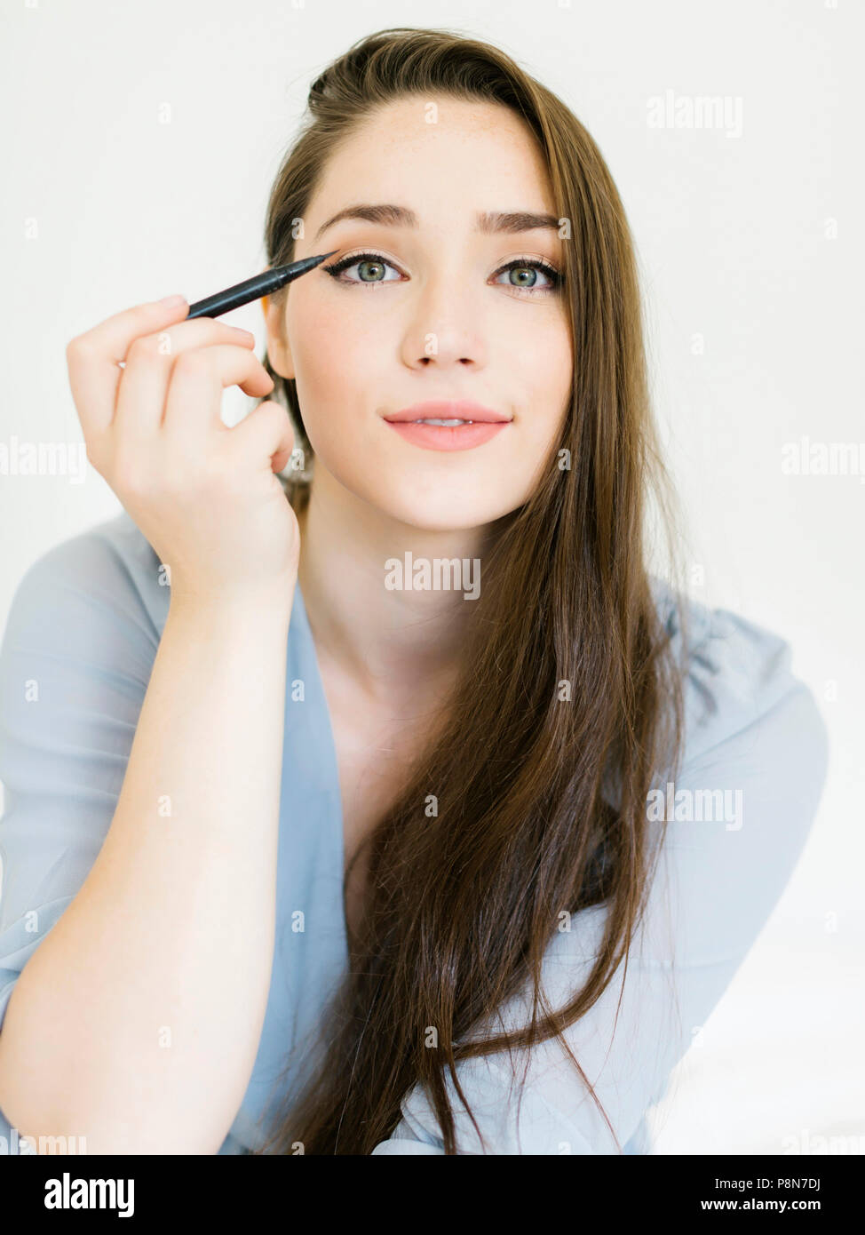 Donna di applicare eyeliner Foto Stock