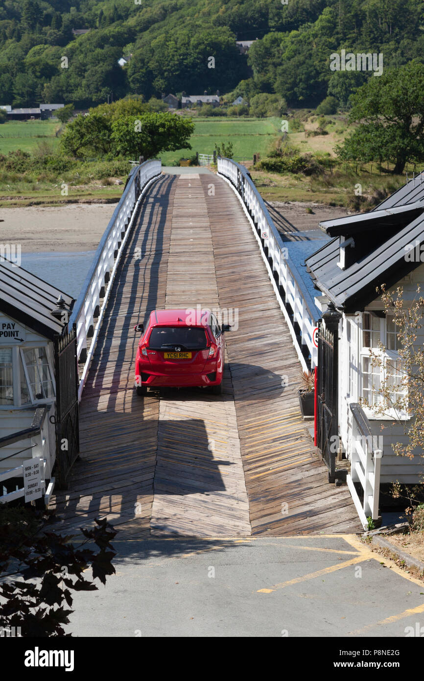 Auto attraversando ponte a pedaggio attraverso il Fiume Mawddach, Penmaenpool, Gwynedd, Galles Foto Stock