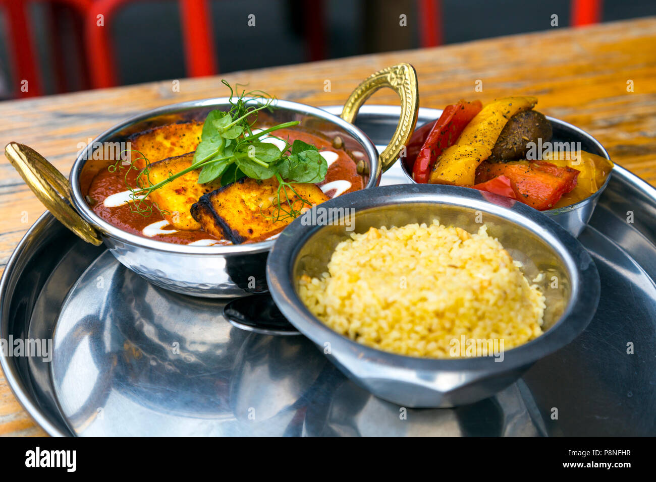 Il paneer indiano piatto con riso e verdure arrosto presso un ristorante (Il Peperoncino sottaceto in Brighton, Regno Unito) Foto Stock