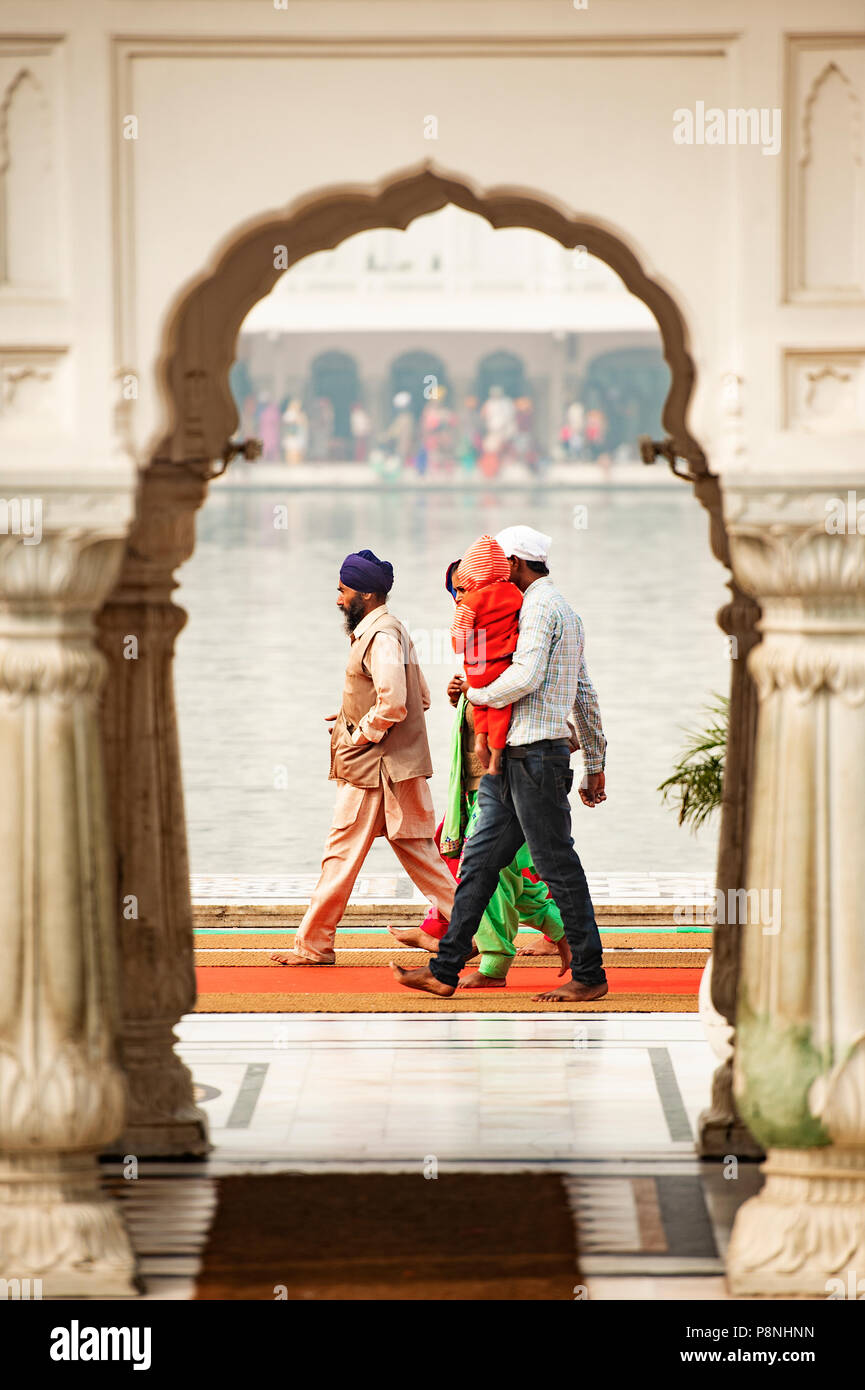 Tempio d'oro - AMRITSAR - INDIA -13 novembre 2017. Una famiglia religiosa sono a piedi intorno al Amritsar Golden Temple in Punjab (India). Il Golden Temp Foto Stock