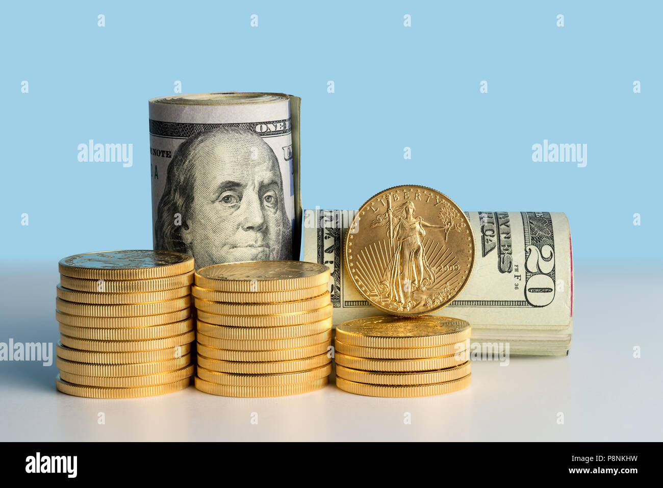 Monete d'oro puro davanti a banca di rotoli di valuta statunitense Foto Stock