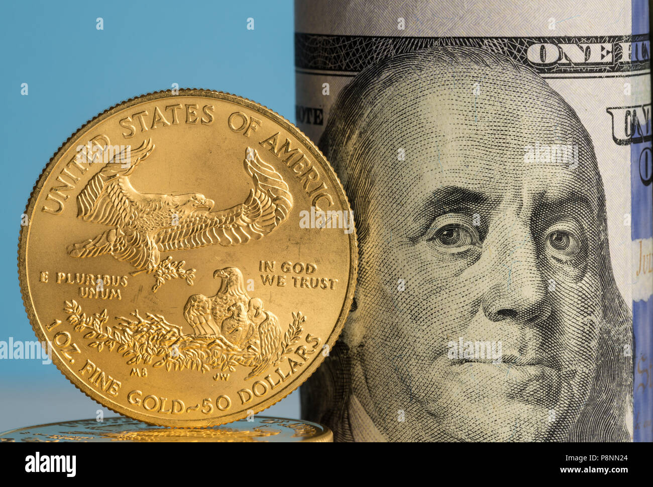 Monete d'oro puro davanti a banca di rotoli di valuta statunitense Foto Stock