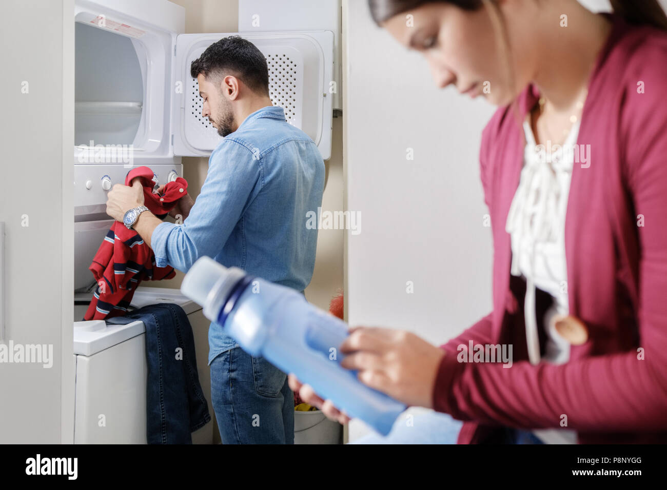 Uomo e donna faccende facendo il bucato Foto Stock