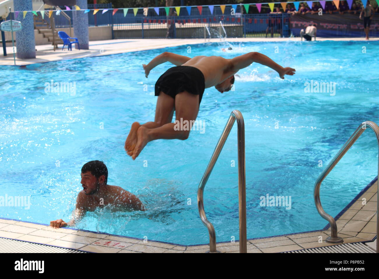 Pepole salto alla piscina di nuoto la concorrenza Foto Stock