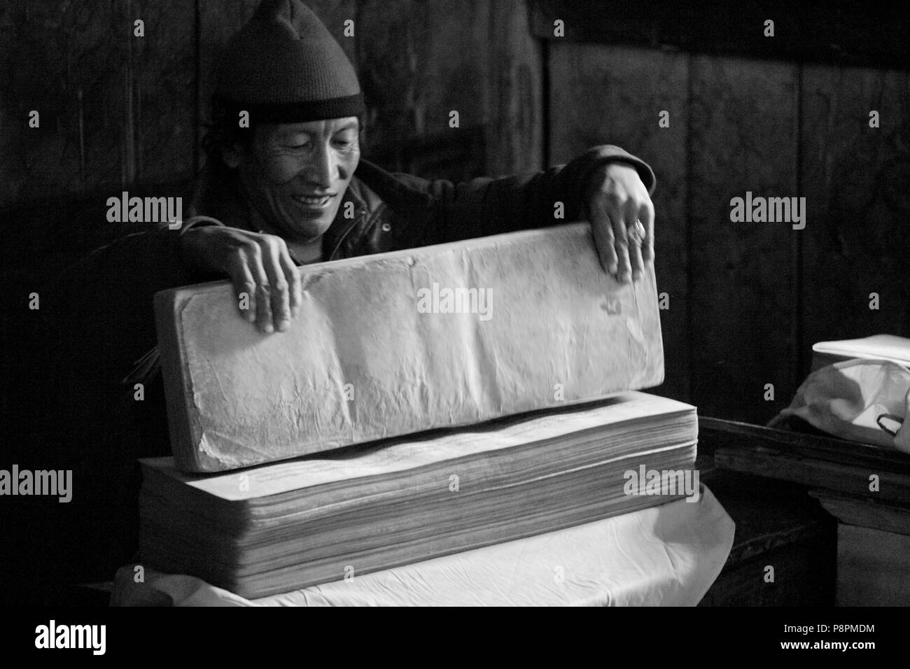 Il Tibetano monaco buddista con testi sacri nel villaggio di SAMDO sul intorno il MANASLU TREK - REGIONE NUPRI, NEPAL Foto Stock