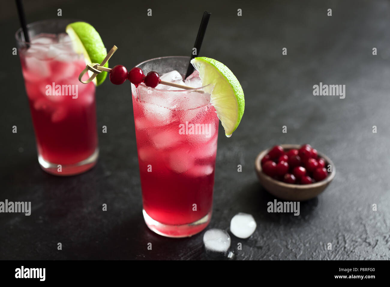 Cape Codder Cocktail con calce e ghiaccio. Mirtillo palustre e la vodka alcol Cape Codder Cocktail su sfondo nero. Foto Stock