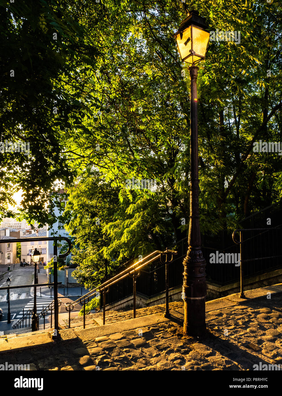 A Paris Street scene di sunrise e nella zona di Montmartre con strade di ciottoli e ornato lamposts Foto Stock