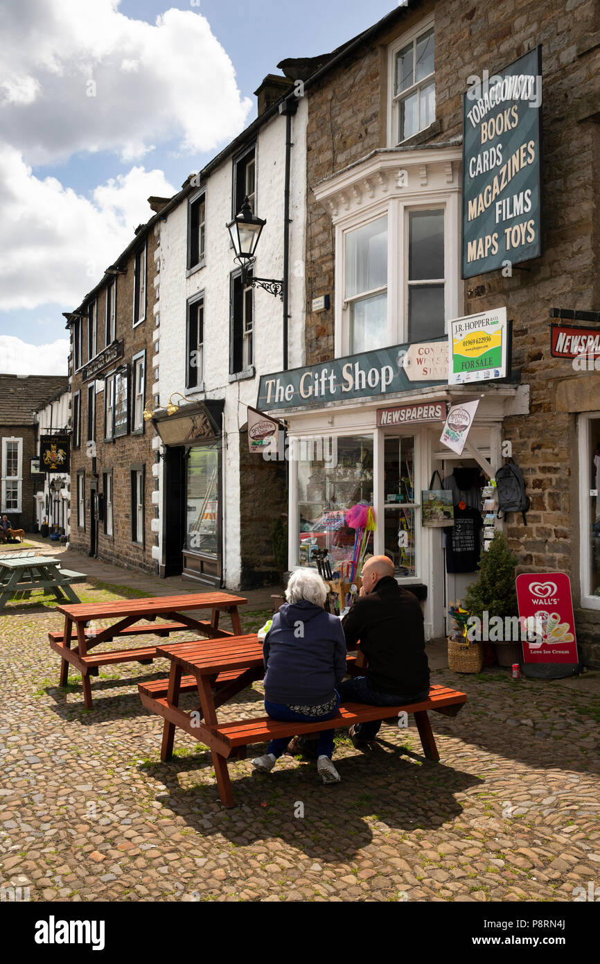 Regno Unito, Inghilterra, Yorkshire, Swaledale, Reeth, Triangolo, i clienti al di fuori del negozio di articoli da regalo Cafe Foto Stock