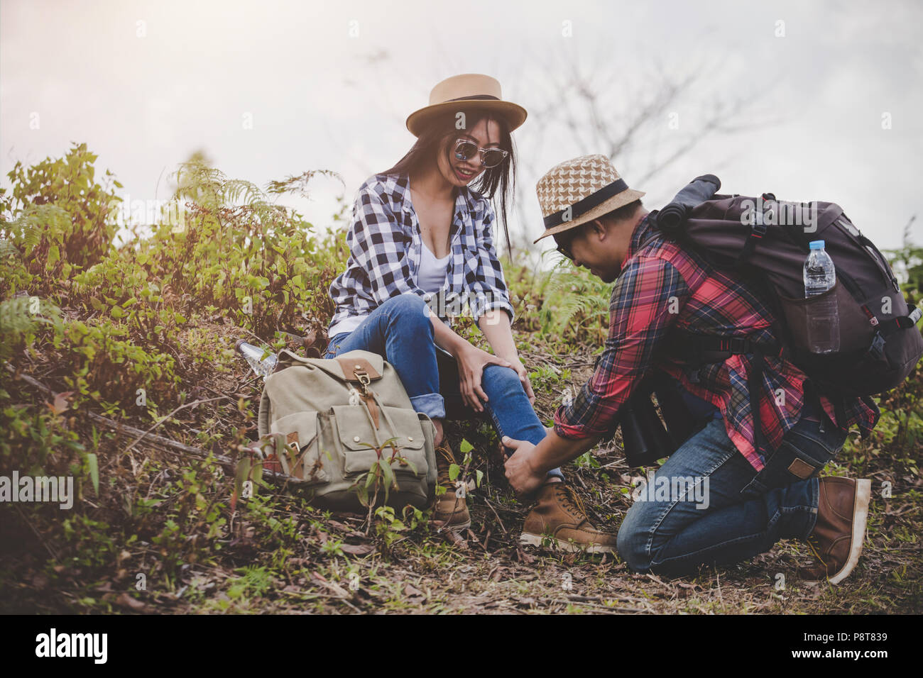 Asian coppia giovane ai viaggiatori di escursionismo caviglia pregiudizio su uno sfondo verde, escursionismo concetto. Foto Stock