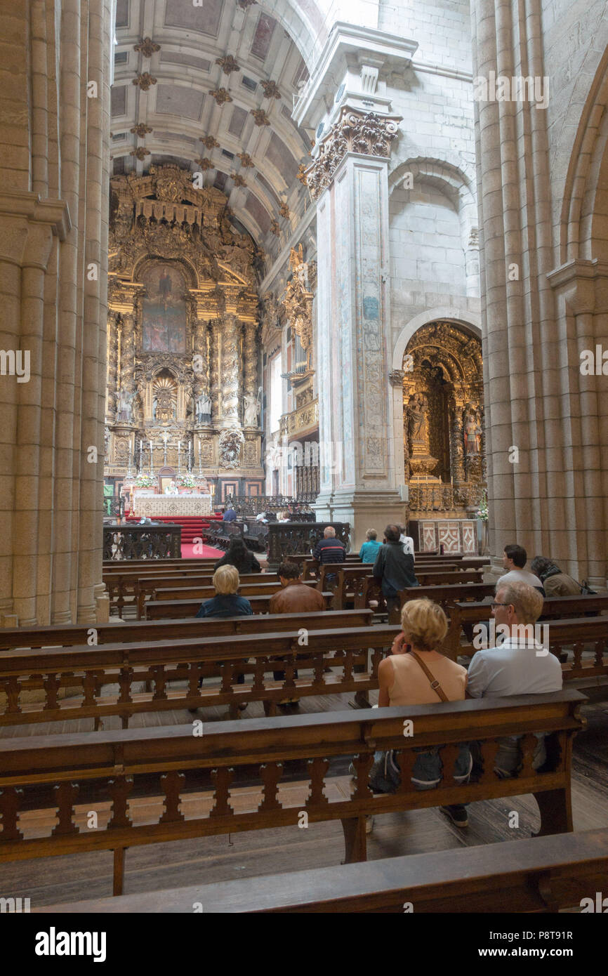 La navata in stile romanico e altare maggiore della Cattedrale di Oporto, Portogallo. Iniziato nel tardo XII sec. molte modifiche poiché compreso il Barocco. Foto Stock