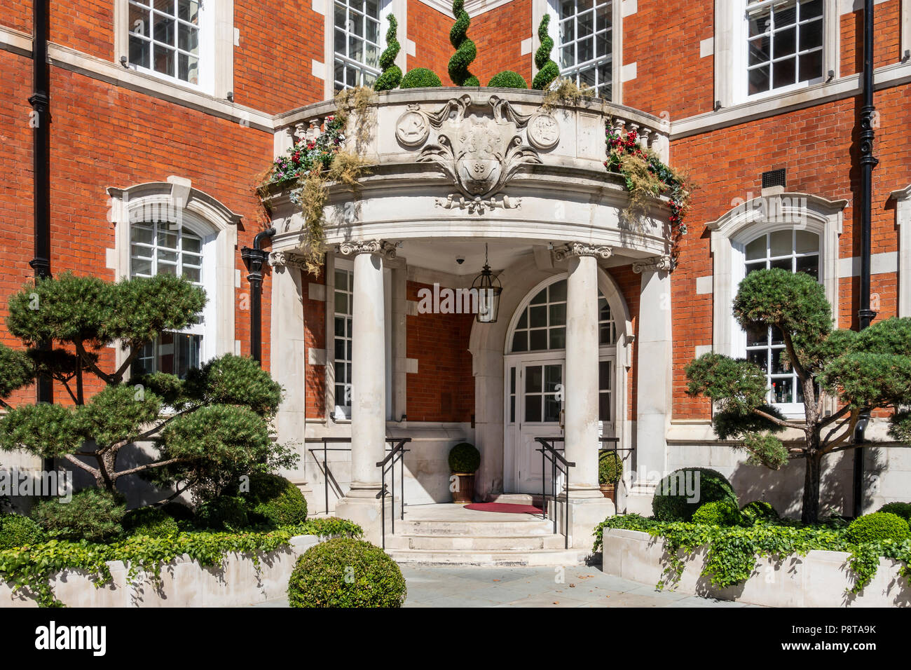 Porta di ingresso per l'Indiano di proprietà a cinque stelle LaLiT hotel a Londra in Inghilterra nell'ex St Olave School. Topiaria da, cloud-alberi sfoltiti, box sfere. Foto Stock