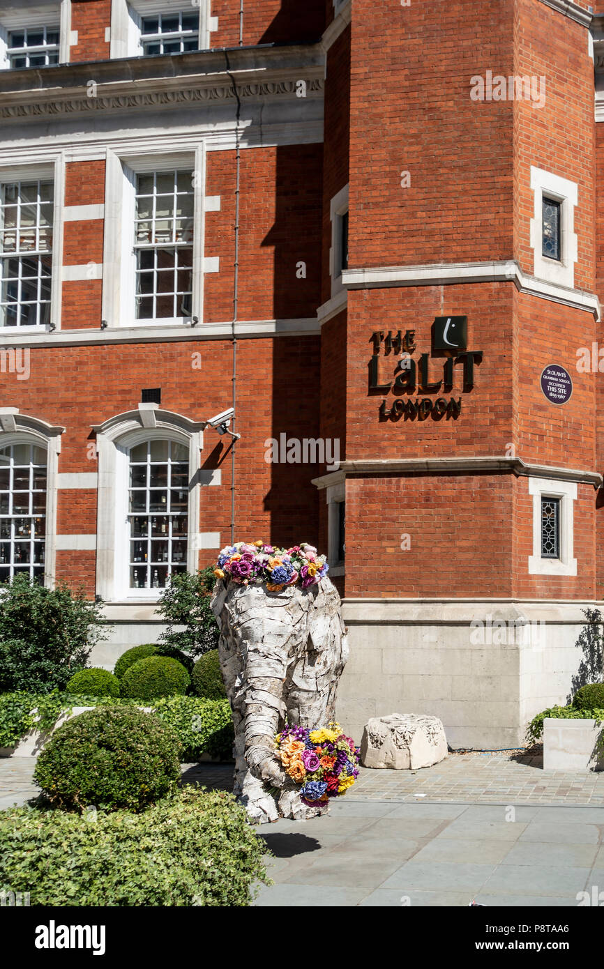 Statua di elefante con fiori al di fuori del Five Star Indian-owned Lalit Hotel nel centro di Londra, costruito nell'ex St Olave school. Inghilterra, Regno Unito Foto Stock