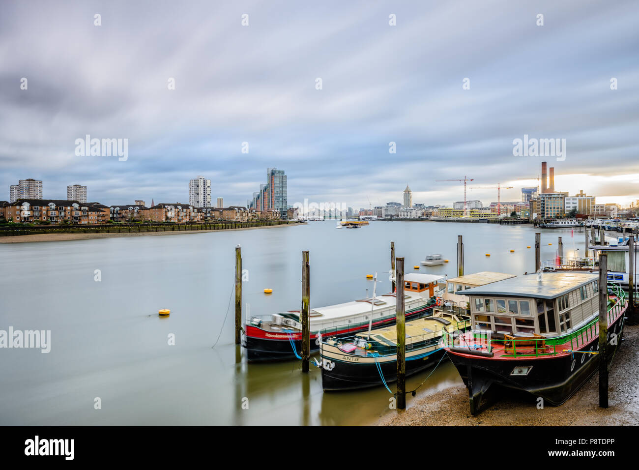 Panorama dal ponte di Battersea, Londra, guardando verso Chelsea Bridge e lavori di costruzione lungo il fiume Tamigi, con la casa di barche e chiatte Foto Stock