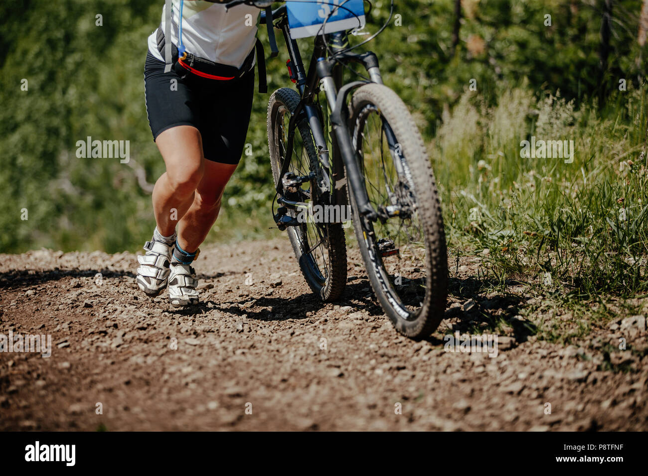 Gambe donna ciclista salita sul sentiero mountain bike race Foto Stock