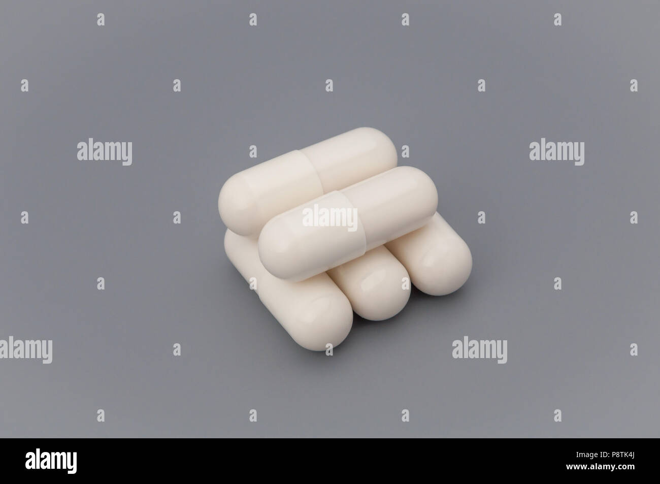 Un paio di pillole di bianco su sfondo grigio. Foto Stock