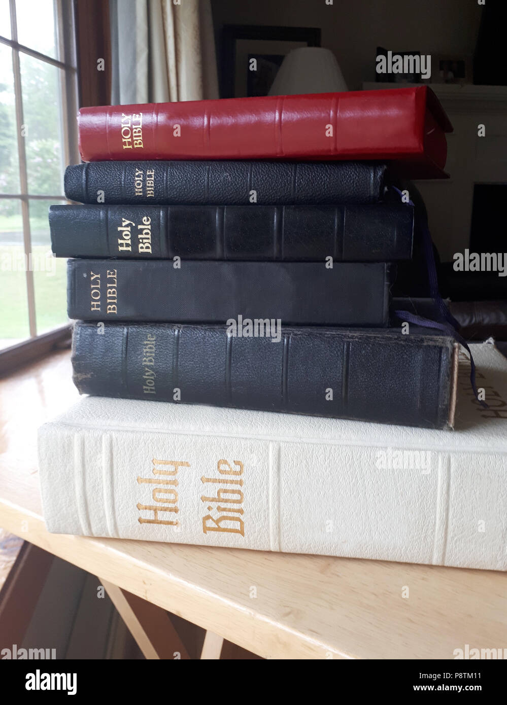 Cinque bibbie impilati su un tavolo Foto Stock