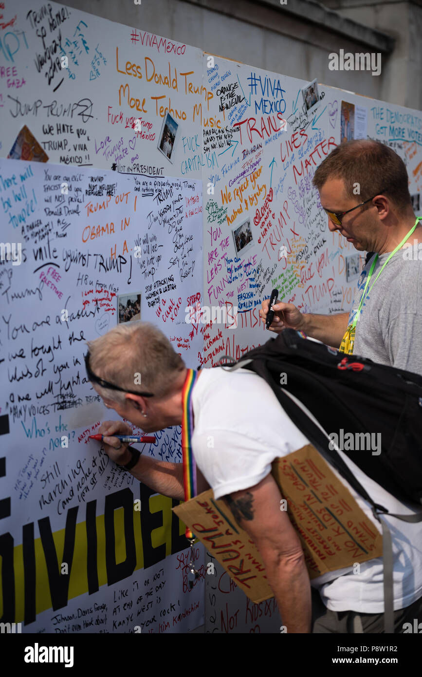 Persone che scrivono sulla parete Awaaz con commenti per Donald Trump. Decine di migliaia di persone hanno marciato e protestato contro la Trump visita al Regno Unito. Il mese di marzo è iniziato in Regent Street e si è conclusa a Trafalgar Square. Foto Stock