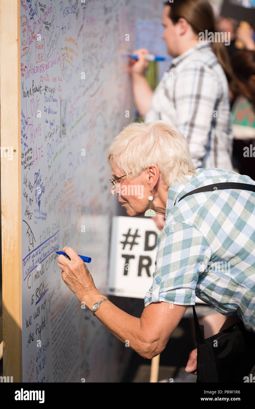 Persone che scrivono sulla parete Awaaz con commenti per Donald Trump. Decine di migliaia di persone hanno marciato e protestato contro la Trump visita al Regno Unito. Il mese di marzo è iniziato in Regent Street e si è conclusa a Trafalgar Square. Foto Stock