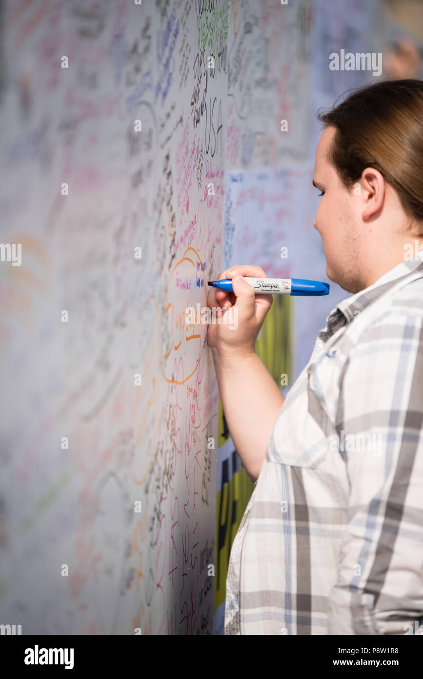 Persone che scrivono sulla parete Awaaz con commenti per Donald Trump. Decine di migliaia di persone hanno marciato e protestato contro la Trump visita al Regno Unito. Il mese di marzo è iniziato in Regent Street e si è conclusa a Trafalgar Square. Foto Stock