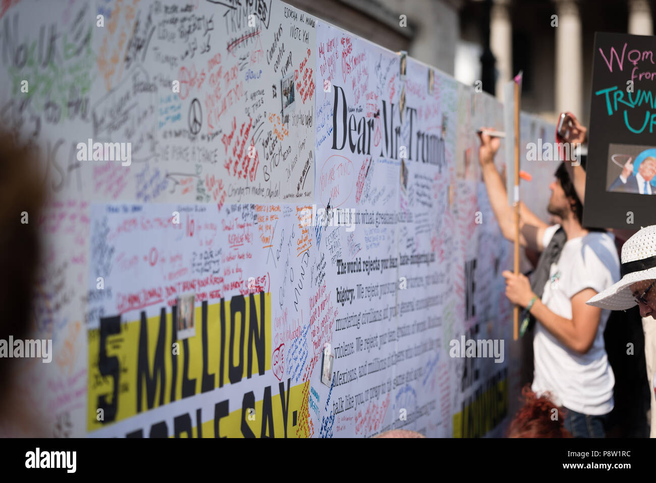 Persone che scrivono sulla parete Awaaz con commenti per Donald Trump. Decine di migliaia di persone hanno marciato e protestato contro la Trump visita al Regno Unito. Il mese di marzo è iniziato in Regent Street e si è conclusa a Trafalgar Square. Foto Stock