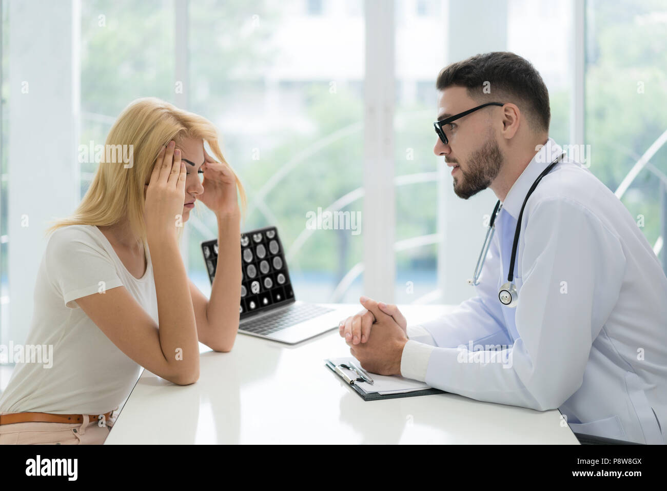 L'uomo medico spiegando la diagnosi per il paziente. Donna cerca paziente preoccupato quando ascolto bed news. Foto Stock