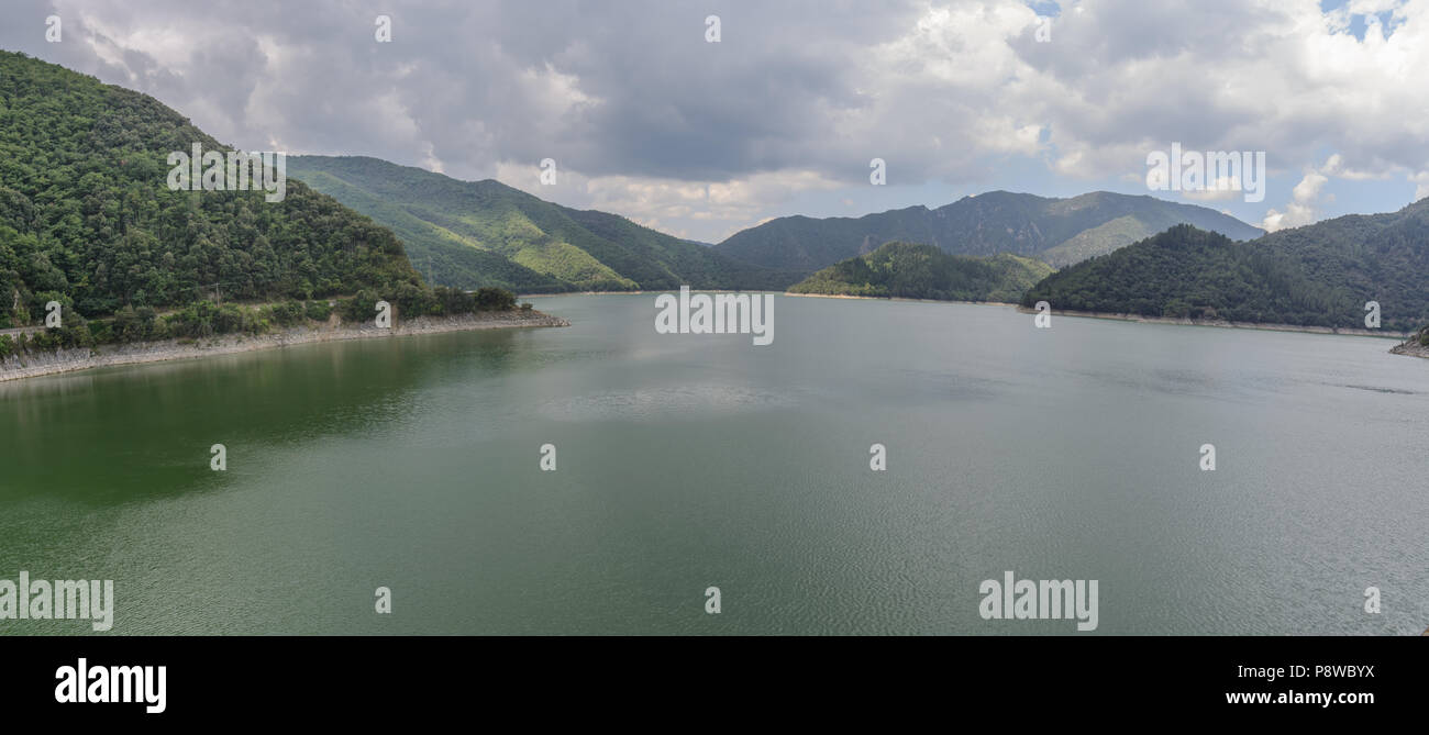 Un ultra wide panorama ripreso durante la stagione primaverile di un fiume di acqua verde e le sue montagne circostanti a amer, Spagna Foto Stock