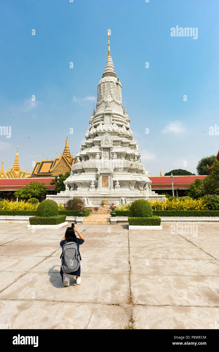 Donna turistica prendendo una fotografia di un bianco Stupa nel palazzo reale di Phnom Penh Cambogia Foto Stock