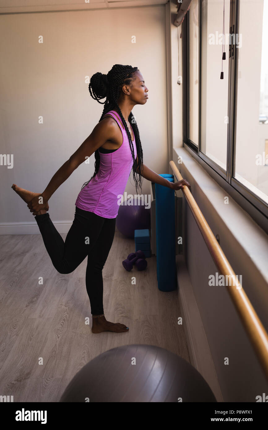 Donna di eseguire barre esercizio Foto Stock