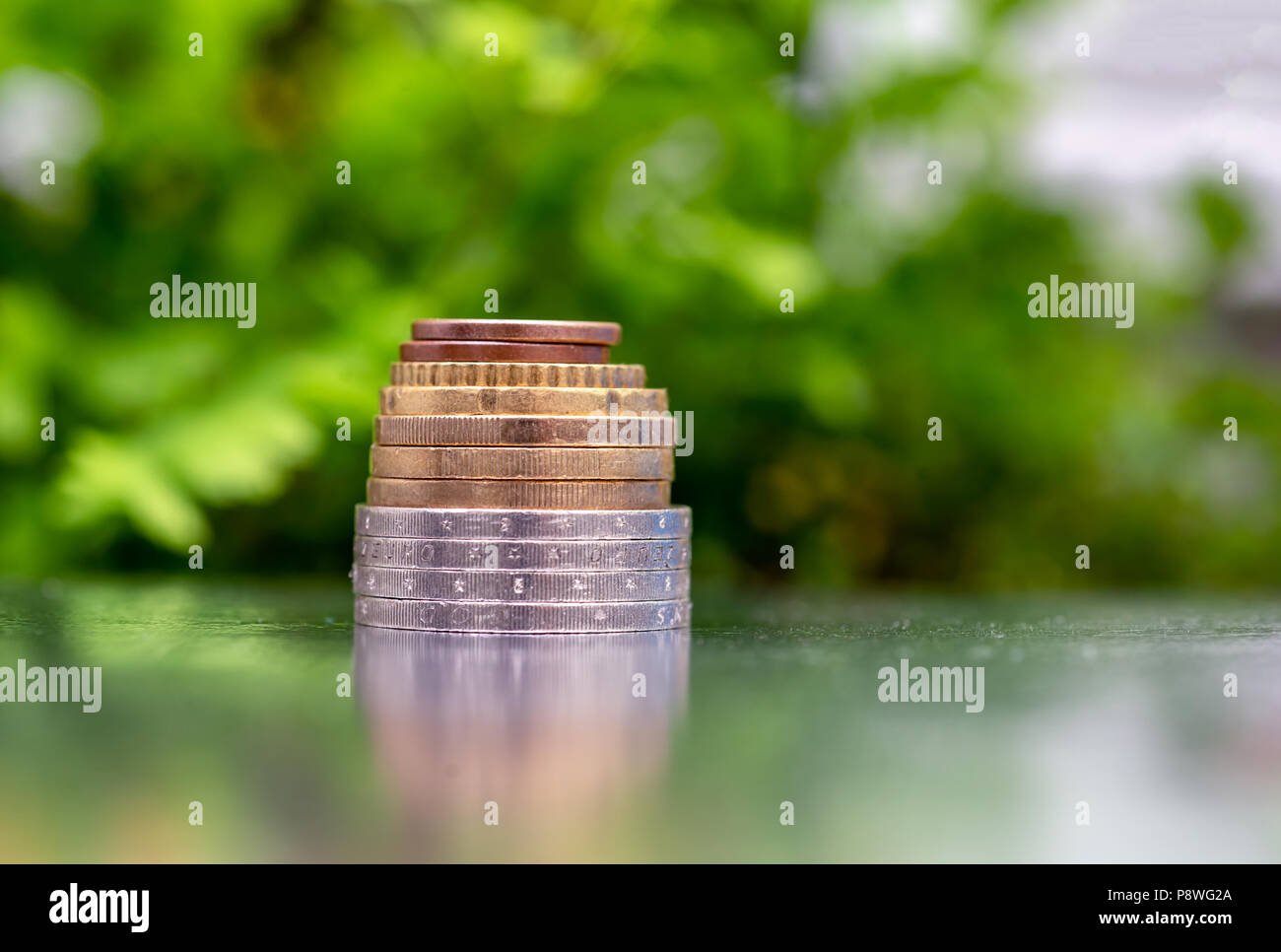 Golden e Silver monete su sfondo verde. Il denaro il concetto di crescita. Foto Stock