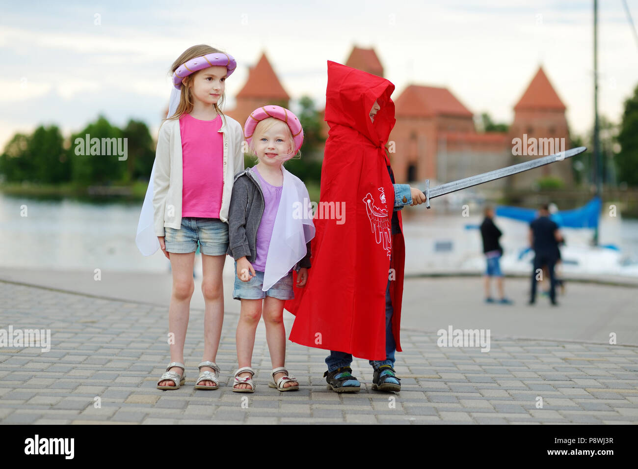 Tre bambini vestiti di principesse e un cavaliere costumi avendo  divertimento all'aperto Foto stock - Alamy