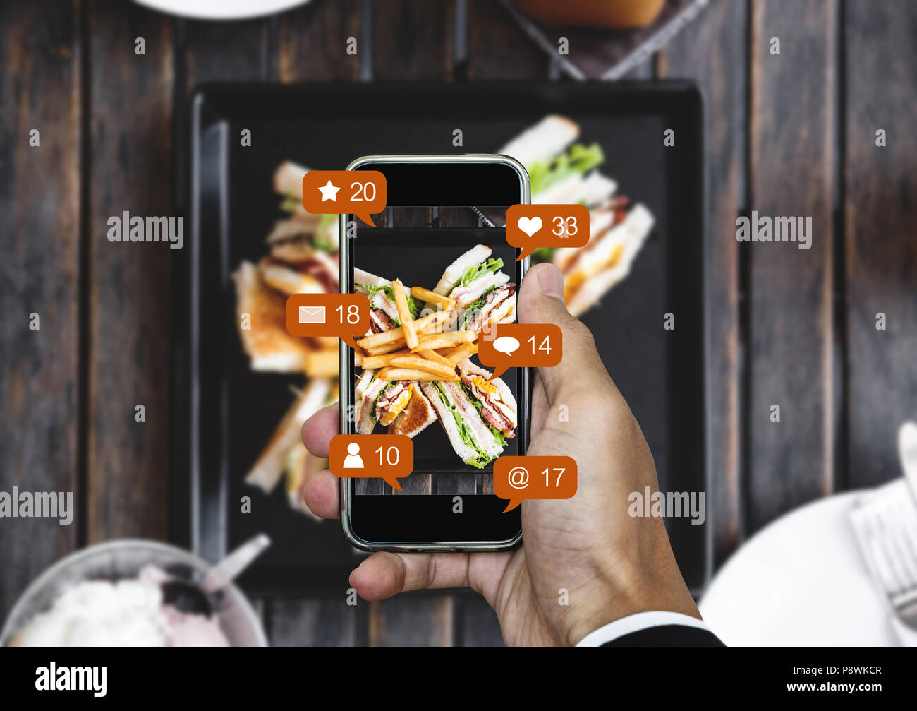 Prendendo il cibo fotografia di mobile smart phone e la condivisione sui social media, rete sociale con le icone di notifica Foto Stock