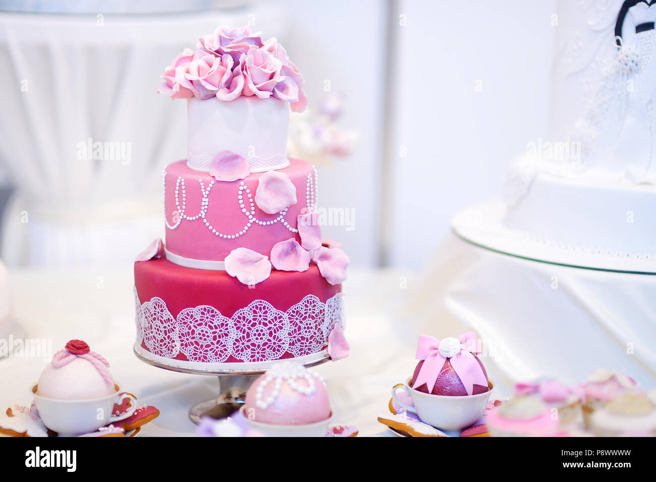 White torta nuziale decorata con rosa fiori di zucchero Foto Stock