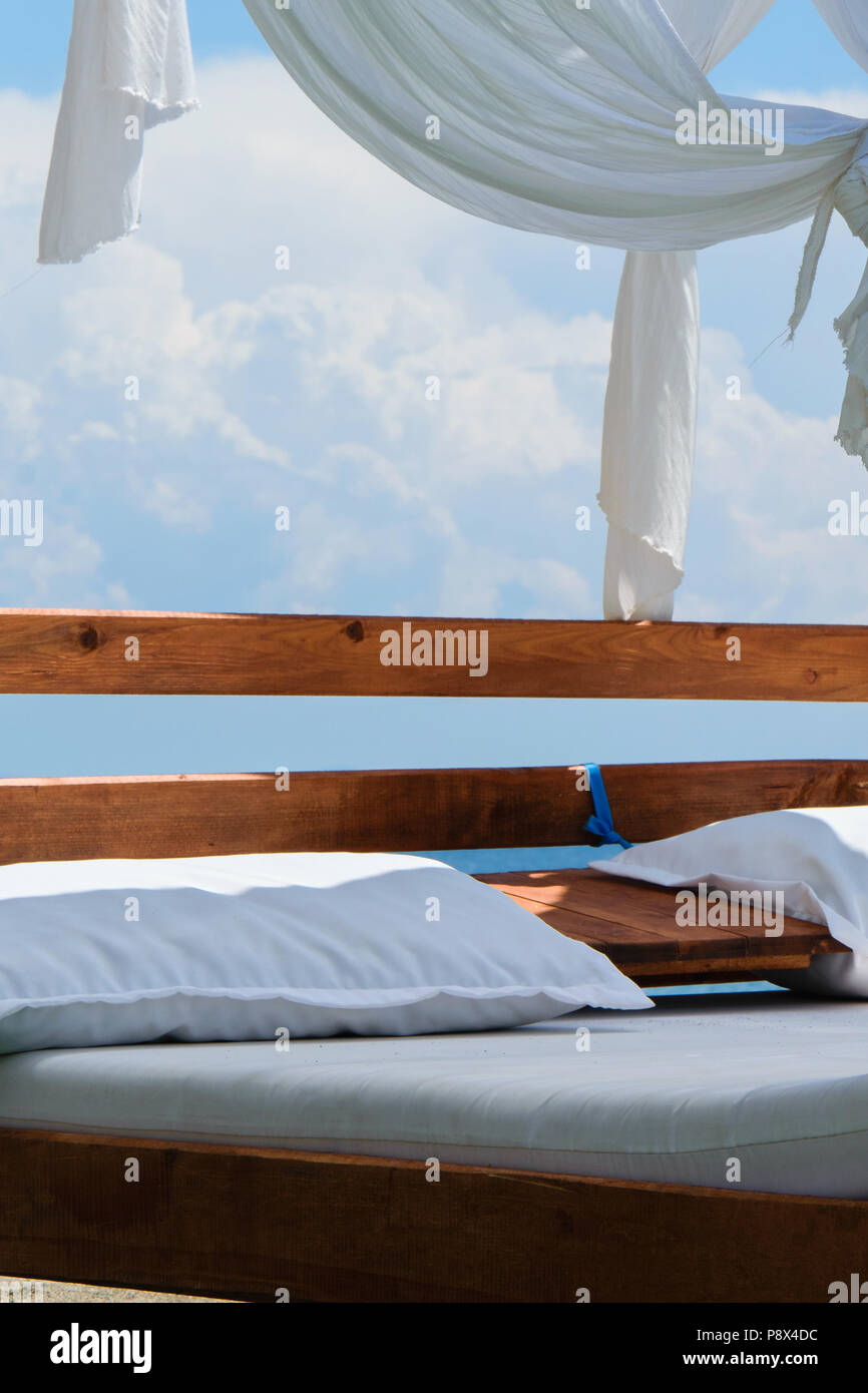 Lusso e romantico bed in riva al mare per i vostri momenti di relax (festività/vacanze), bianchi e soffici nuvole in background Foto Stock